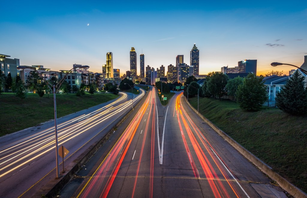 Timelapse photo of headlights and brakelights blurring down a divided highway.