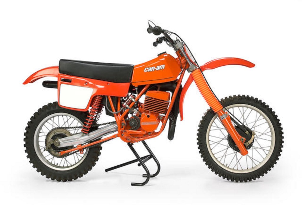 An orange 1980 Can-Am MX6 motocross motorcycle on a center stand