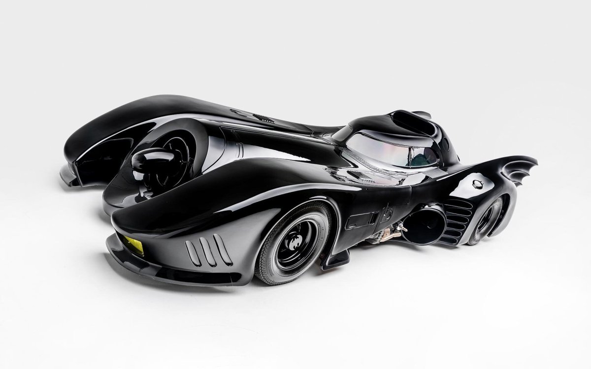 A 3/4 front view of the 1989 Batmobile from Tim Burton's Batman movie. Car is displayed in a white studio background.