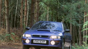 A blue 1997 UK-market GC8 Subaru Impreza WRX (Turbo 2000) in a forest