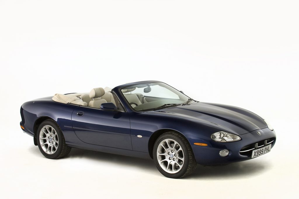A dark-blue 2001 Jaguar XK8 Convertible in a white studio