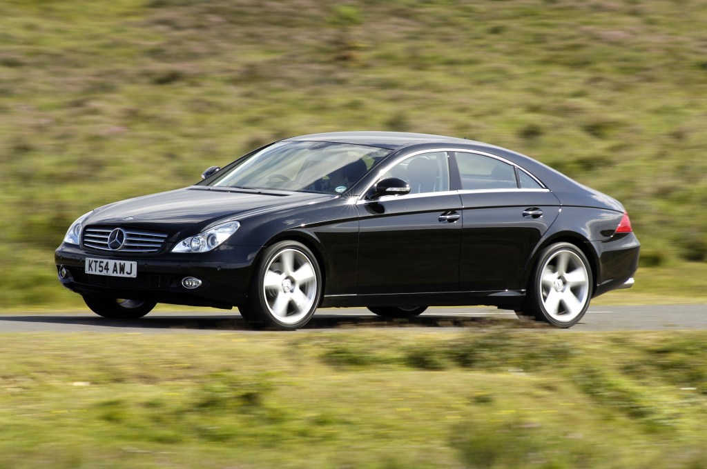 A black 2005 Mercedes CLS 500 driving down a country road