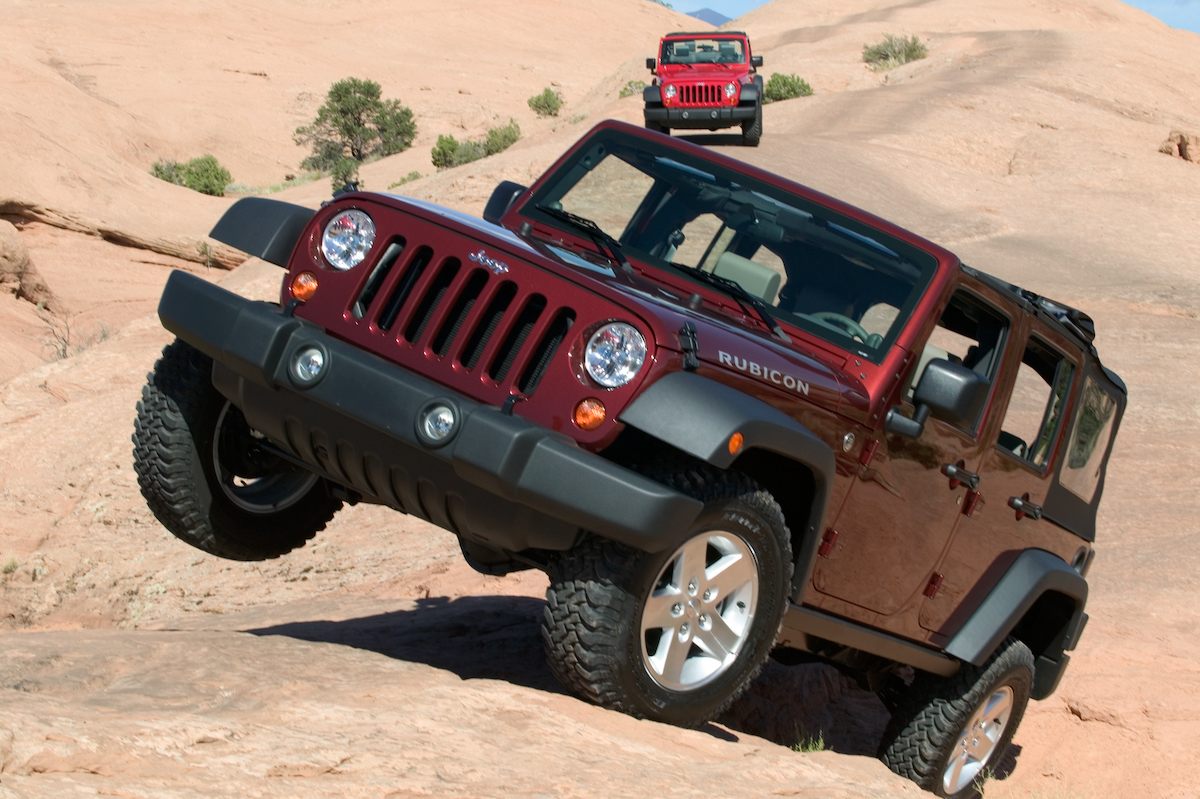 A red Jeep Wrangler climbing up a steep desert path. Jeep Wrangler years to avoid