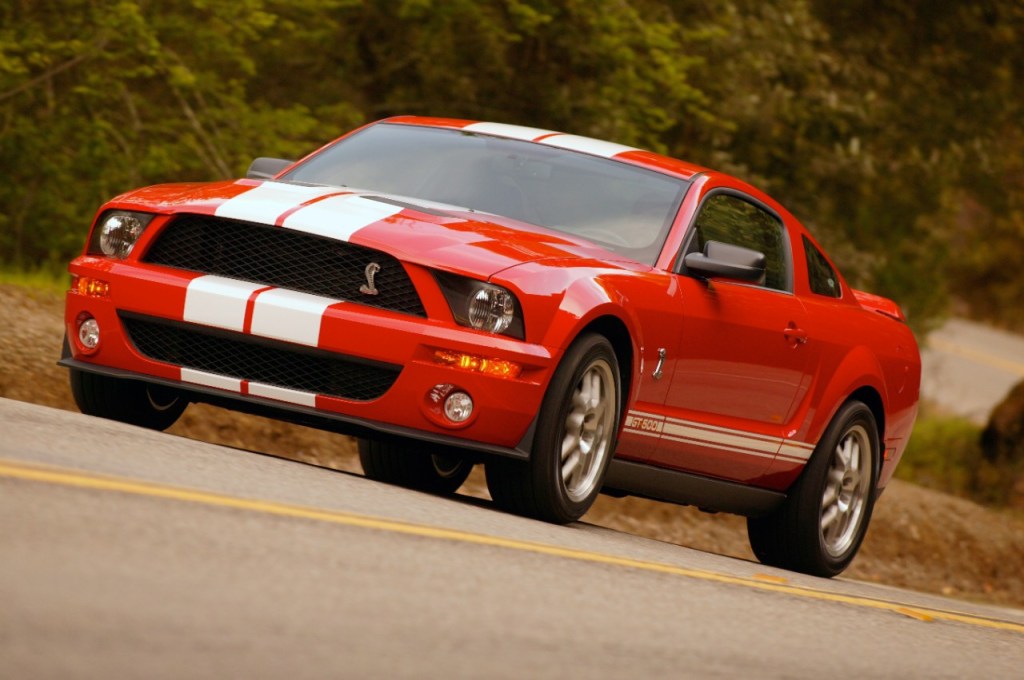 Red and white 2007 Ford Mustang Shelby GT500 coupe on winding mountain road