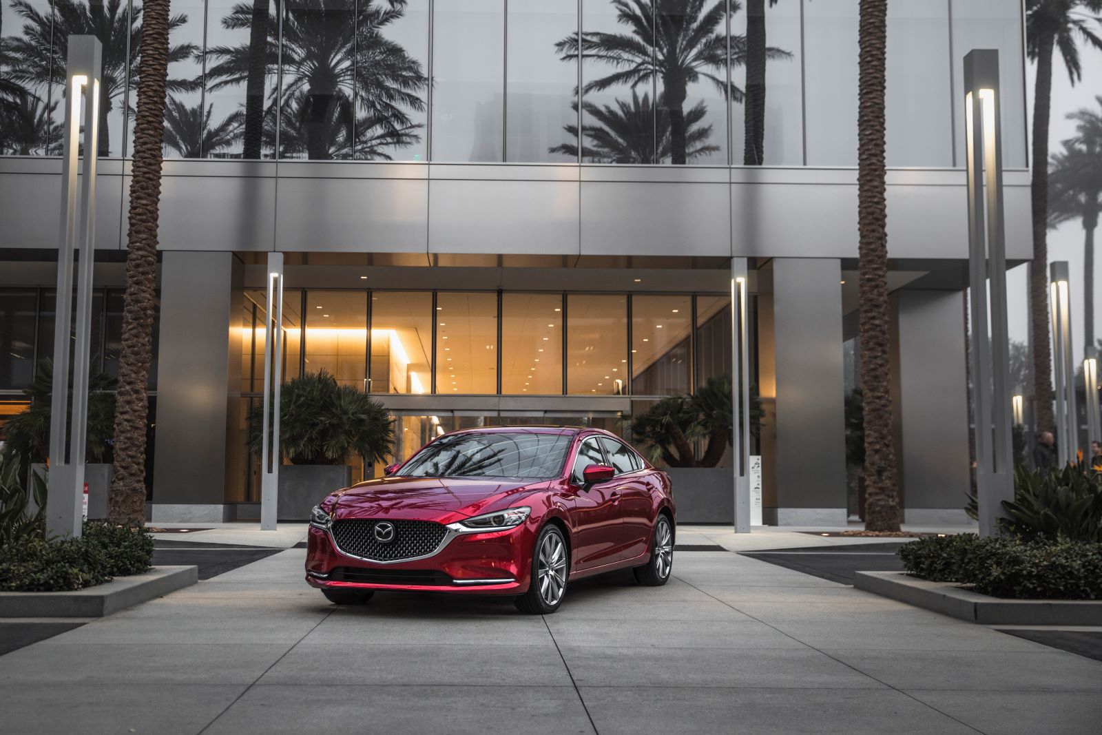 Staged shot of a 2019 Mazda6, one of the most reliable used cars, set against a backdrop of an expensive house surrounded by palm trees