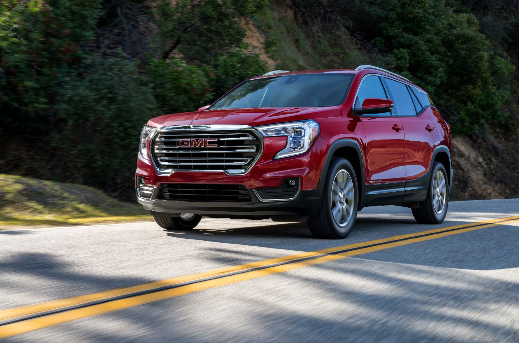 2022 GMC Terrain SLT compact SUV in red driving on a strip of highway