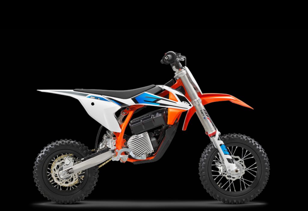 The side view of a white-orange-and-blue 2022 KTM SX-E 5 electric dirt bike