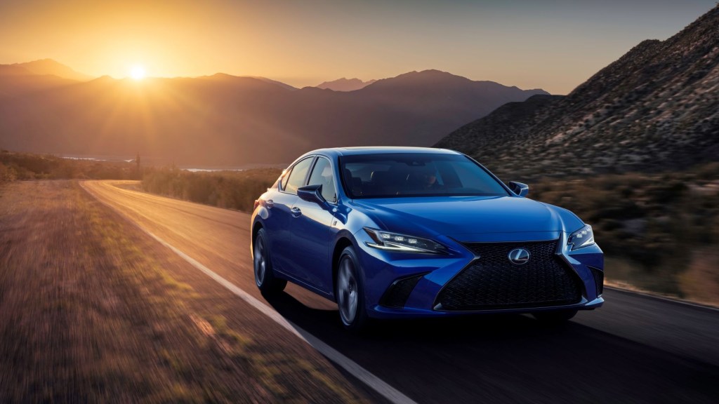 2022 Lexus ES luxury midsize sedan with a blue paint color driving on a highway at sunset