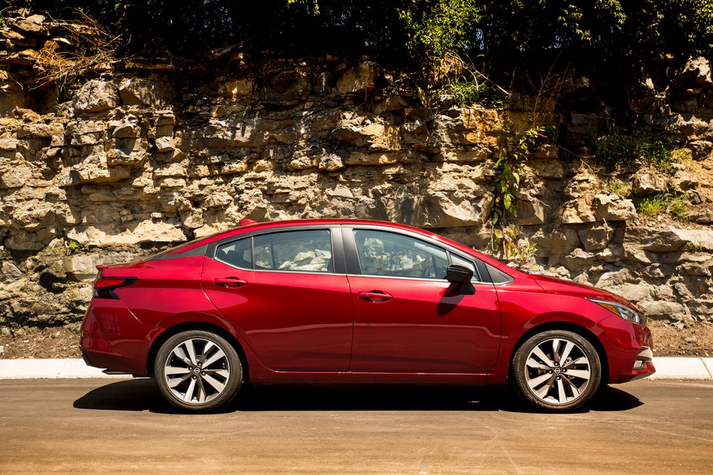 Passenger side of red 2022 Nissan Versa parked on mountain road