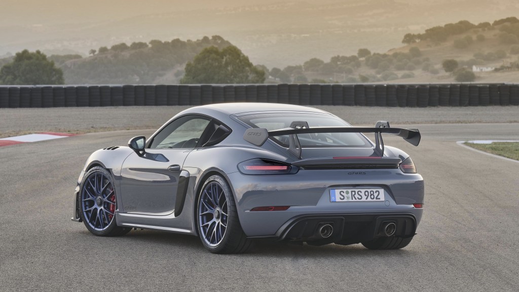 The rear 3/4 view of a gray-and-black 2022 Porsche 718 Cayman GT4 RS with Weissach Package