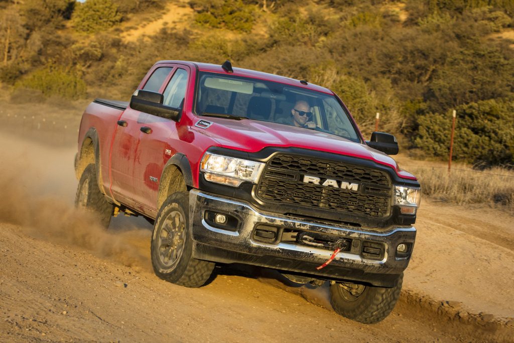 Red Ram Power Wagon truck racing along an off-road trail.