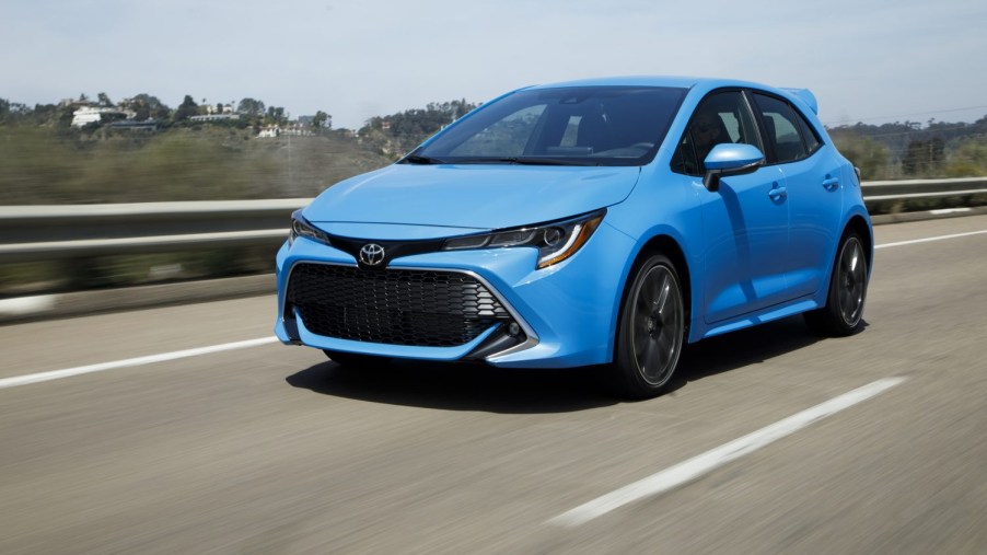 Blue 2022 Toyota Corolla Hatchback XSE Driving down the road shot from front