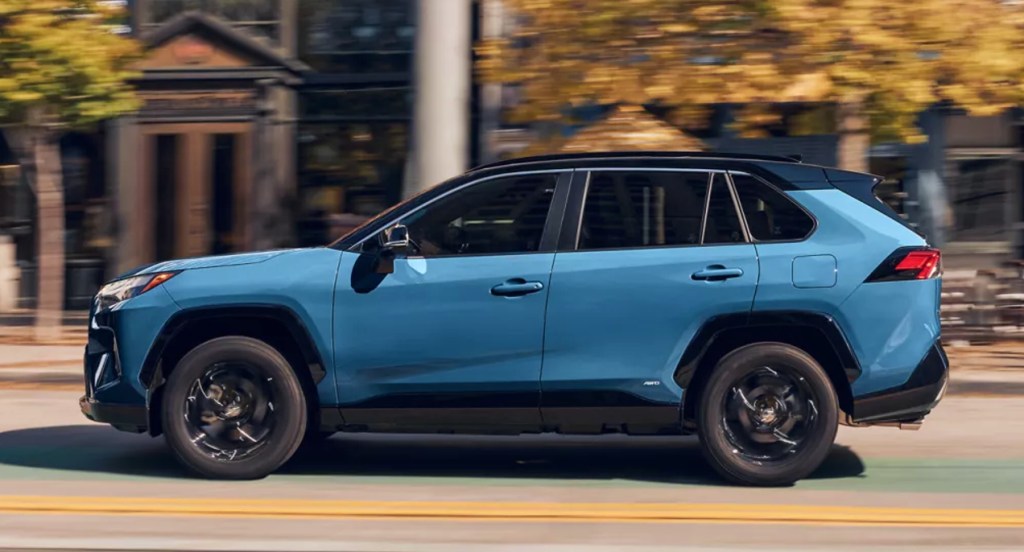 A blue 2022 Toyota RAV4 small SUV is driving on the road. 