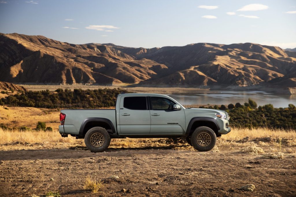 Gray Toyota Tacoma parked by a mountain lake.
