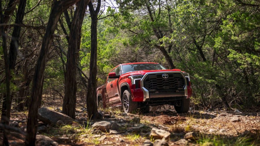 Toyota Tundra with TRD Off-Road package speeding along a dirt road with a cloud of dust in the background.