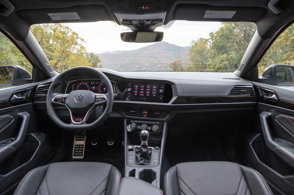 The black-leather front seats and black-and-red dashboard of a 2022 Volkswagen Jetta GLI