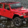 A red 2022 Jeep Wrangler 4x4 parked next to a lake.