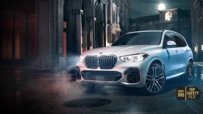 A white 2022 BMW X5 against a city background.