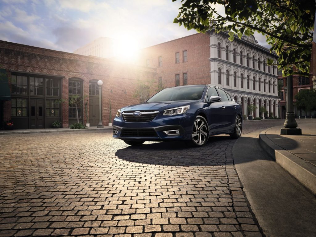 Front angle view of the 2022 Subaru Legacy in dark blue, one of the best cars for new drivers, shown driving on a cobblestone street in a city