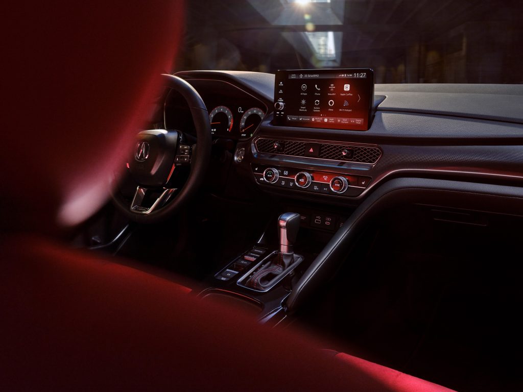 The black dashboard and red front seats of a 2023 Acura Integra with a CVT