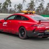 A 3/4 rear view of the red Mercedes-AMG GT 63 S 4Matic+ F1 Medical Car driving on a race track.