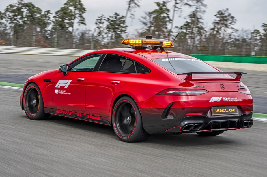 A 3/4 rear view of the red Mercedes-AMG GT 63 S 4Matic+ F1 Medical Car driving on a race track.