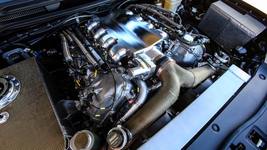 Toyota engine bay with a twin-turbocharged V8 tuned racing engine visible.