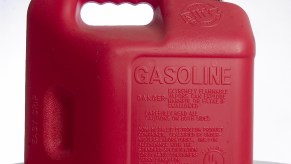 A red plastic Type I gas can in a white studio