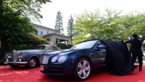 1964 Bentley S3 Saloon parked on a red carpet next to the unveiling of the new Bentley Flying Spur V8 in Japan