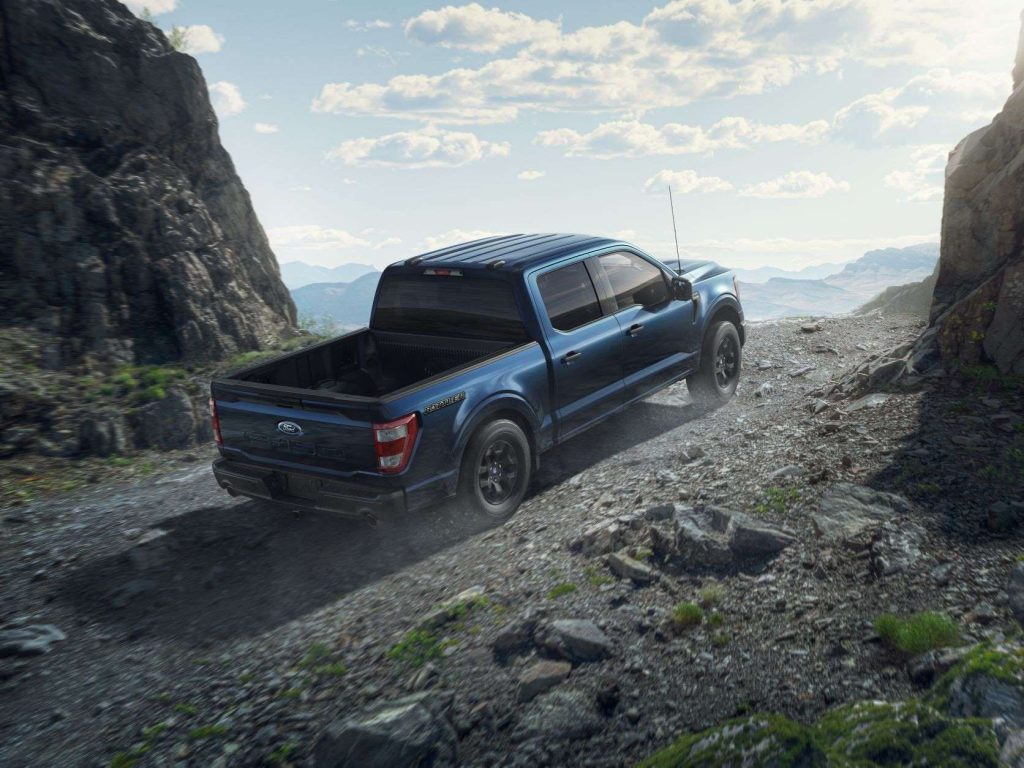 Blue 2023 Ford F-150 Rattler diving up a hill, highlighting its release date, price, and features