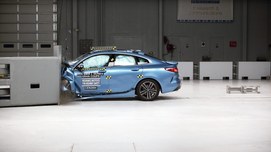 A profile view of a blue BMW 2 Series Gran Coupe being crash tested at the IIHS testing facility.