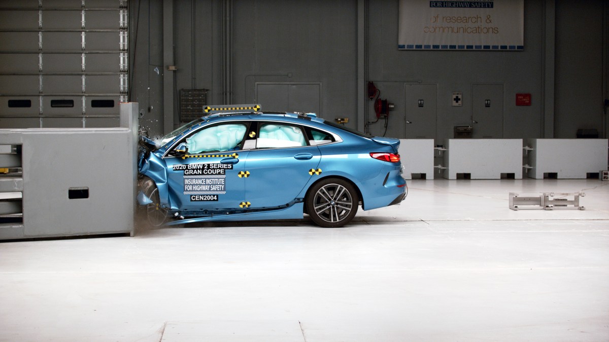 A profile view of a blue BMW 2 Series Gran Coupe being crash tested at the IIHS testing facility.