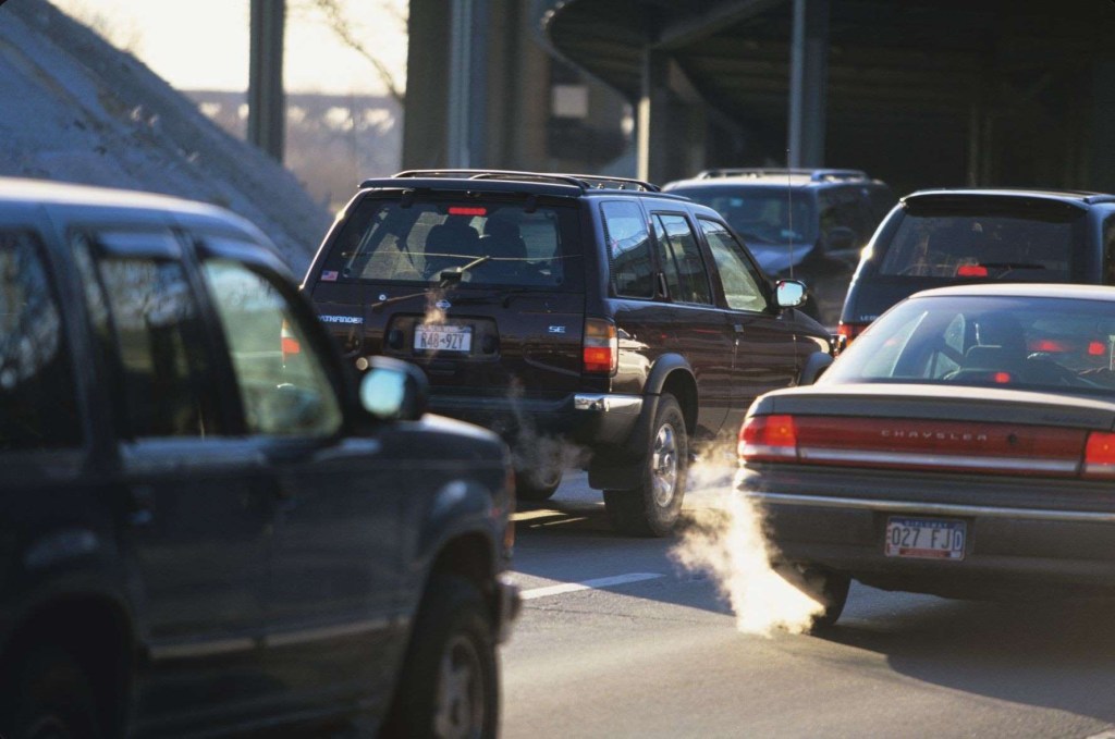 Cars in traffic releasing exhaust fumes, highlighting fuel fragrances that eliminate car exhaust odors