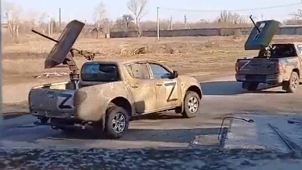 Convoy of ISIS-style Toyota and Mitsubishi pickup trucks used by the Russian military in Ukraine driving on a street