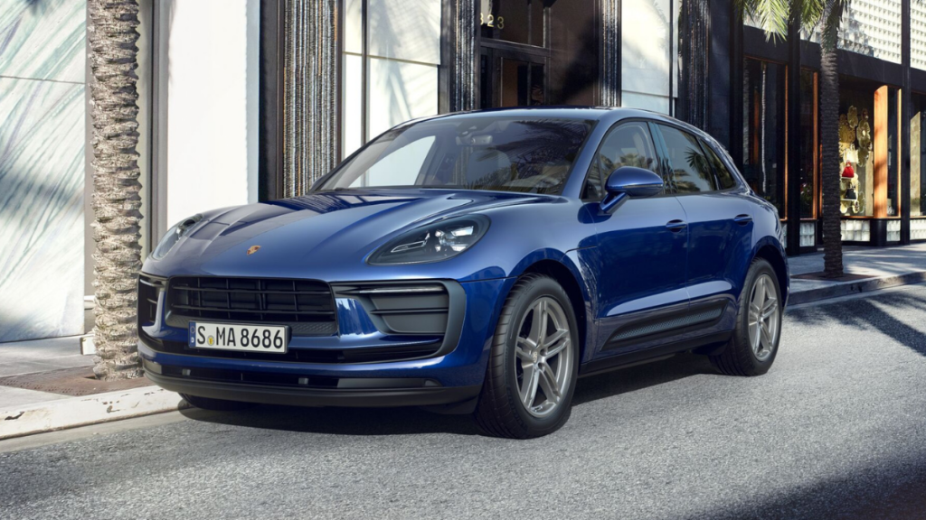 Driver's side front angle view of blue 2022 Porsche Macan, highlighting release date and price of 2023 Porsche Macan EV