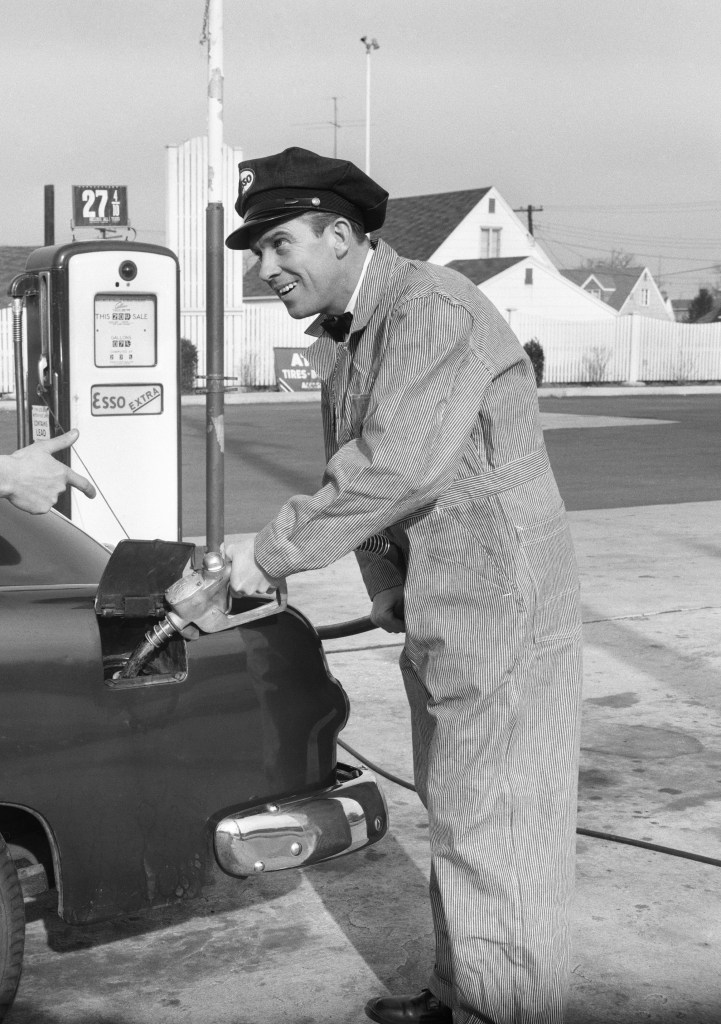 gas station attendant fills up gas tank in black and white