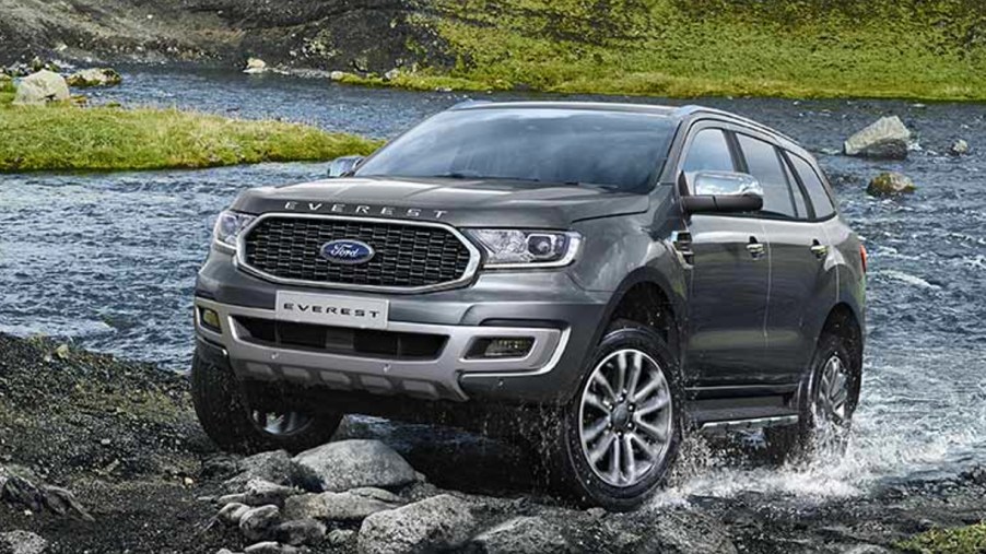 A gray Ford Everest midsize SUV is driving off-road.