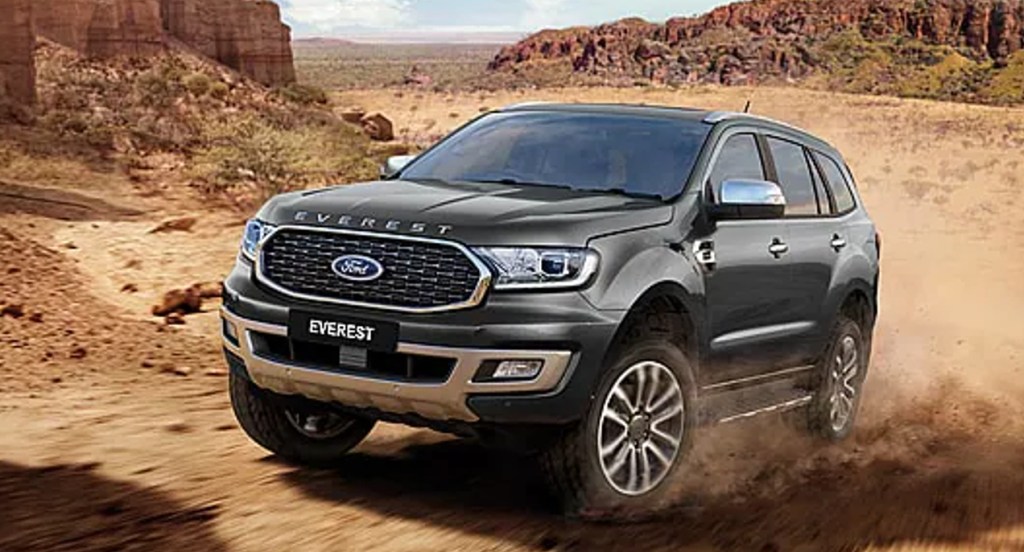 A black Ford Everest SUV is driving off-road. 