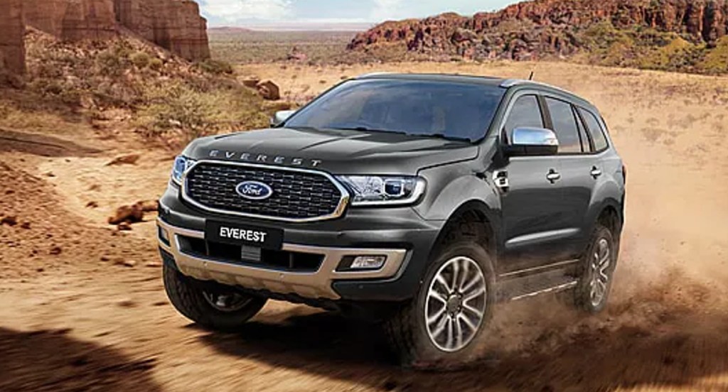 A black Ford Everest SUV is driving off-road.
