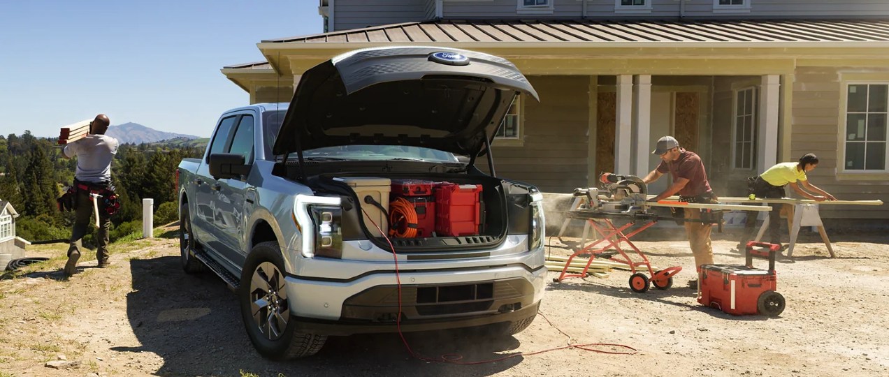 A gray 2022 Ford F-150 Lightning is parked with its frunk open.