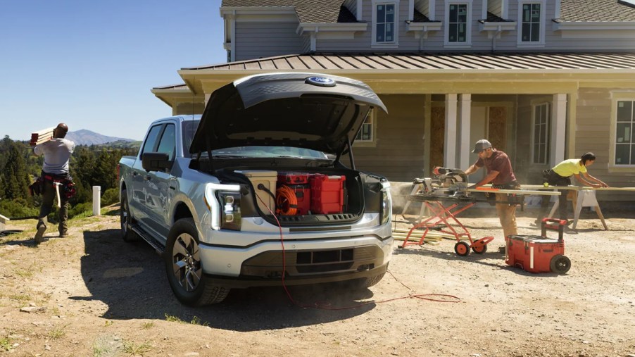 A gray 2022 Ford F-150 Lightning is parked with its frunk open.