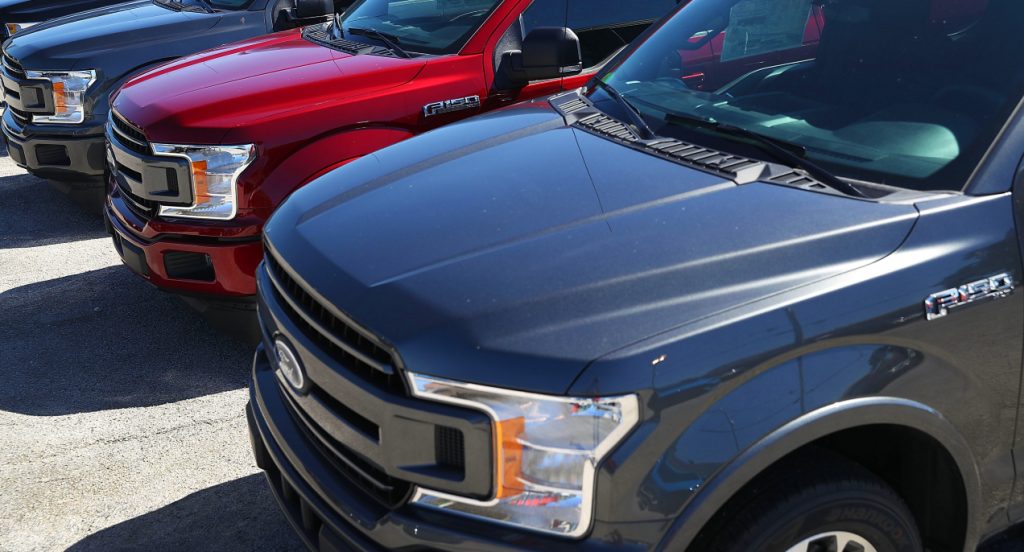 Ford F-150 pickup trucks are parked on a Ford lot. 