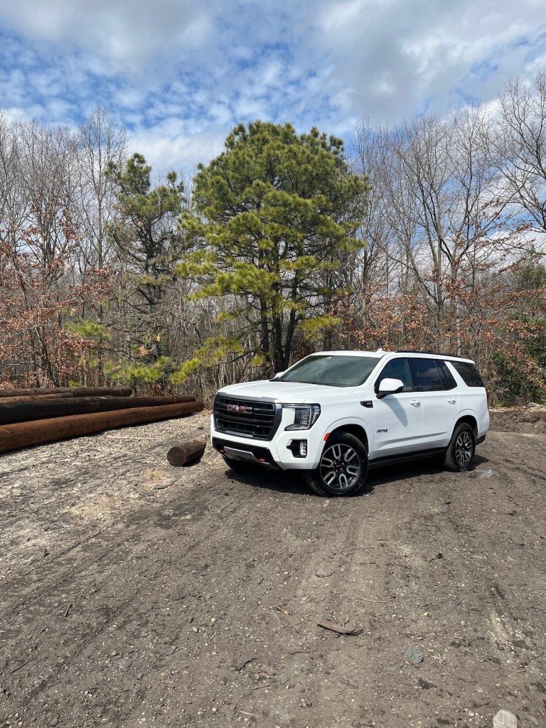 A white 2022 GMC Yukon AT4 parked in a timber lot