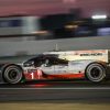 A profile view of a Porsche 919 LMP race car driving at night during the 2017 24 Hours of Le Mans race.