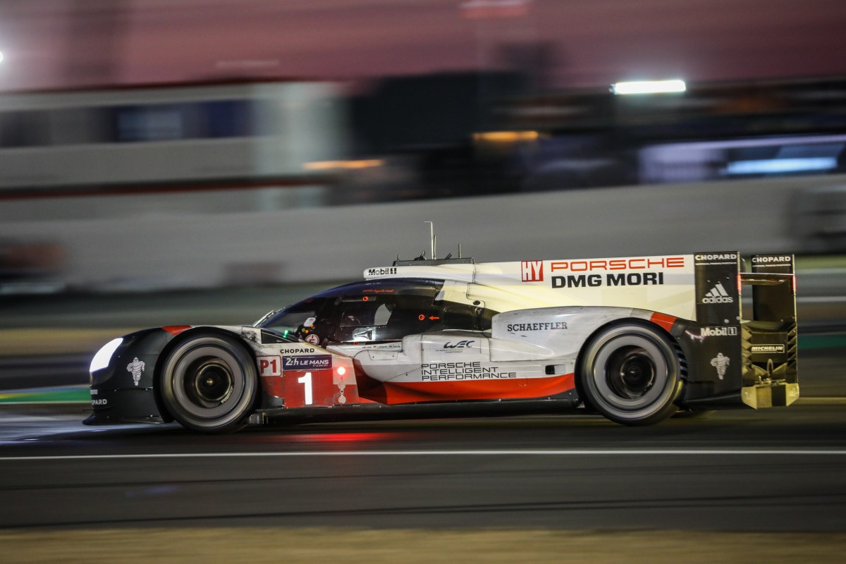 A profile view of a Porsche 919 LMP race car driving at night during the 2017 24 Hours of Le Mans race.