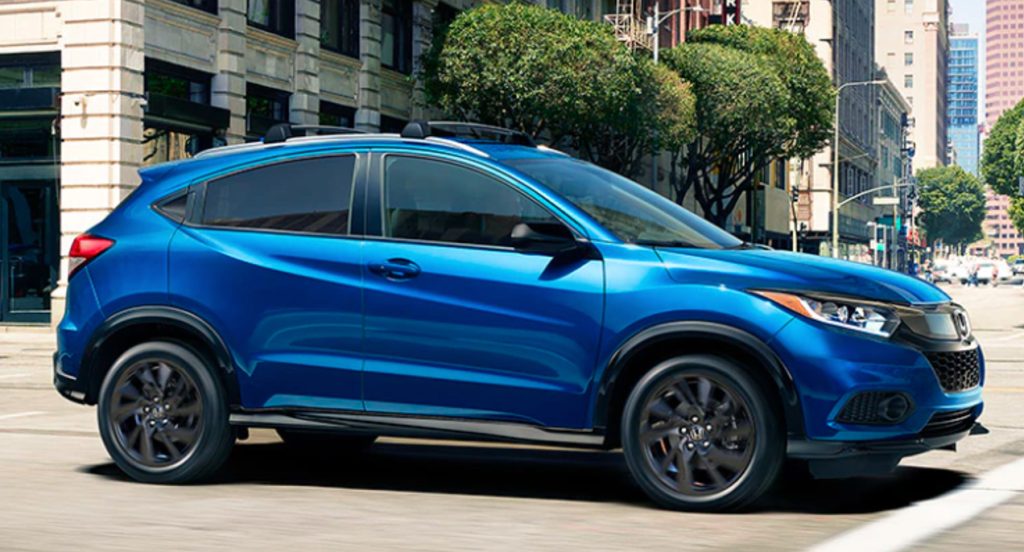 A blue 2022 Honda HR-V small SUV is driving on the road. 