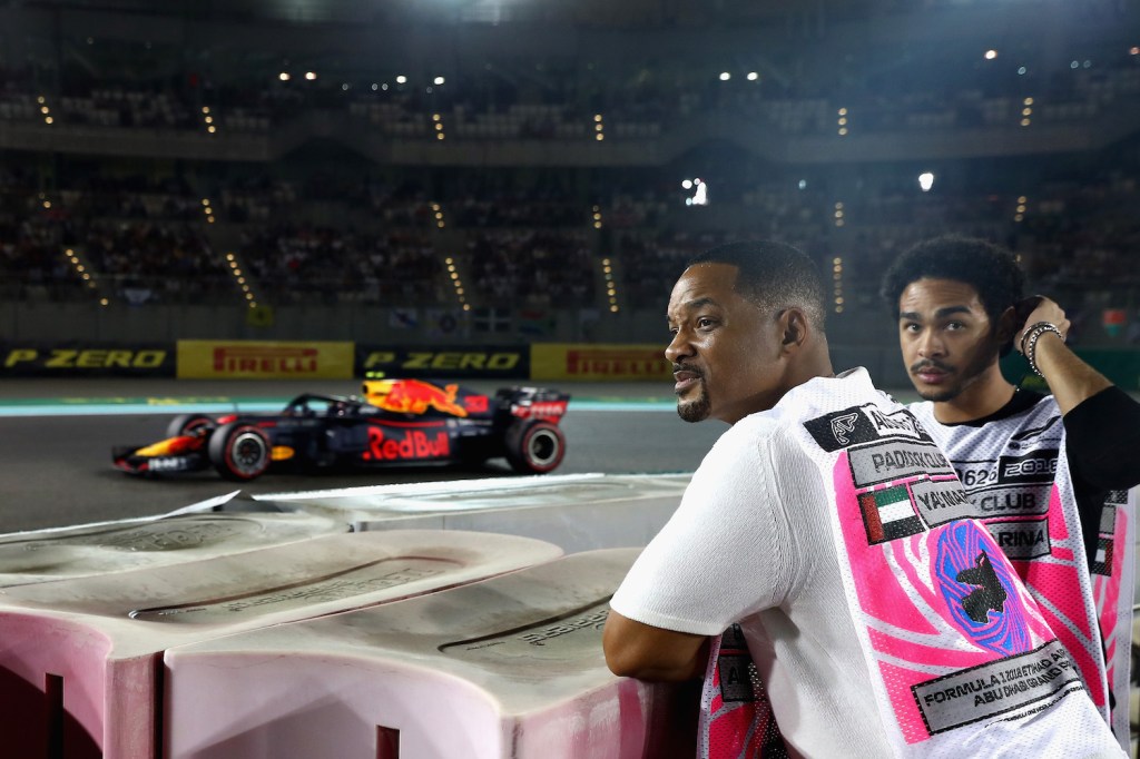 Photo of Will Smith at a race track watching Formula One race cars.