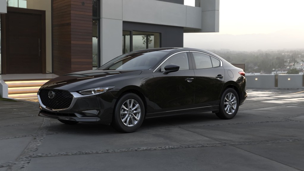 Jet Black Mica 2022 Mazda3 Sedan parked next to a large building