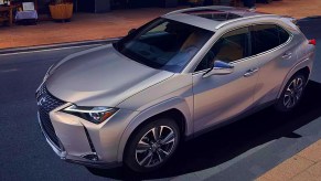 A gray 2022 Lexus UX 250h is driving on the road.