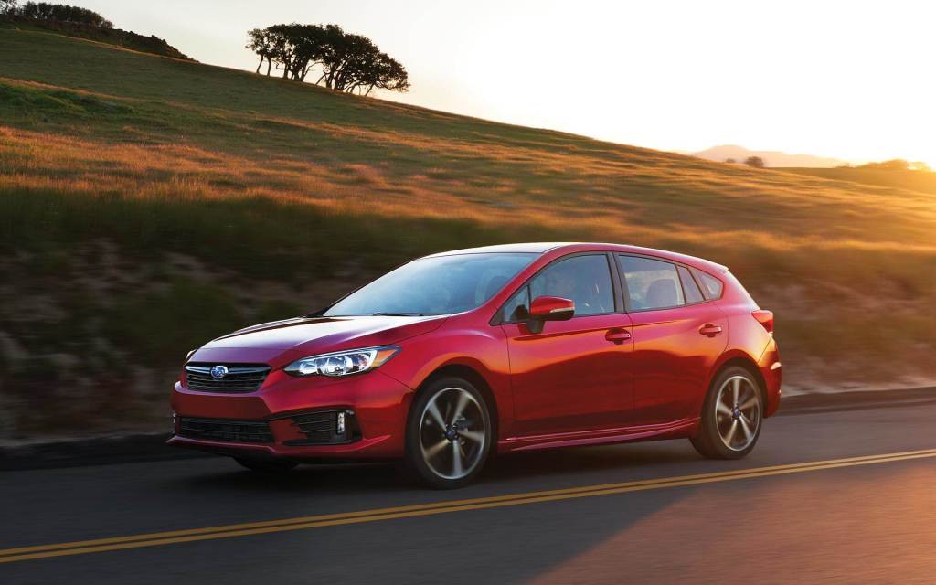 Lithium Red Pearl 2022 Subaru Impreza Hatchback driving by a hill